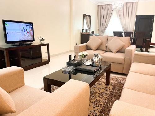 阿可贺巴Al Gosaibi Hotel-Villa的客厅配有两张沙发和一台电视