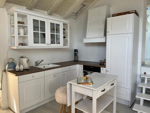 克莱恩 蒙塔纳Les coeurs brisés的厨房配有白色橱柜和桌子
