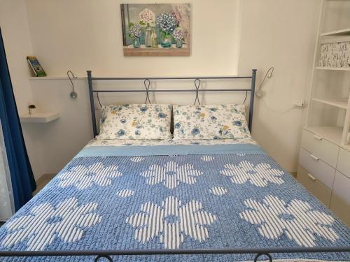 蒙特西尔瓦诺La Casetta的一间卧室配有一张带蓝色和白色床单的床。