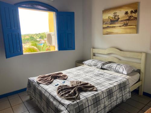 伦索伊斯Pousada Lavramor的一间卧室配有一张床铺,床上有毯子