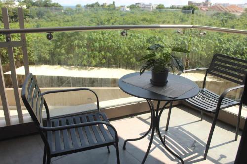 Maribagofamily vacation accomodation的阳台上的桌椅,种植了盆栽植物