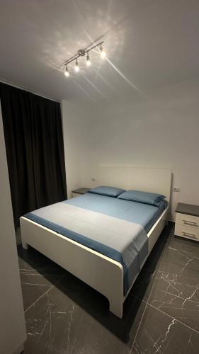圣金Sole apartments的一间卧室配有一张带蓝色床单的大床