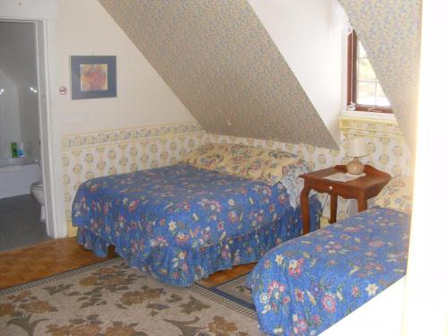 圣加布里尔德瓦尔卡捷Auberge La Seigneurie Valcartier的一间小卧室,配有两张床和一张桌子