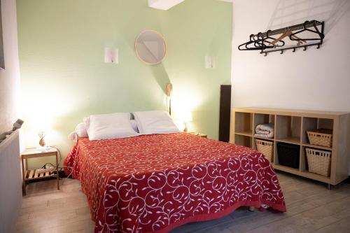 阿普特Hôtel-restaurant le Palais的一间卧室配有一张带红色毯子和镜子的床
