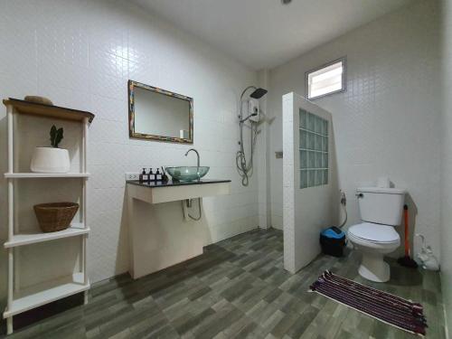 通萨拉尼尼亚里度假屋的一间带卫生间、水槽和镜子的浴室