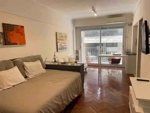 布宜诺斯艾利斯Studio Palermo Hermoso Con Balcon的一间卧室设有一张床和一间客厅。