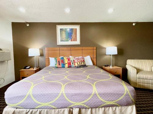 昆西The Quincy Inn & Suites的一间卧室配有一张大床和两盏灯。