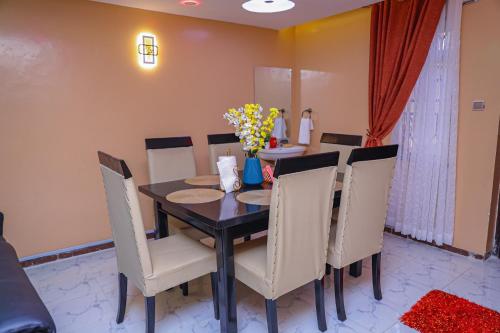 纳库鲁Milimani Apartment Comfy Homestay的一间带桌椅和鲜花的用餐室