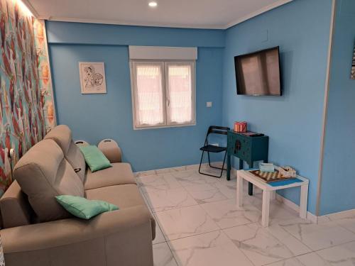 桑坦德Apartamento Zona Playa y centro Ciudad的客厅设有蓝色的墙壁、一张沙发和一张桌子