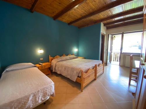 圣贾科莫Albergo Nazionale的一间卧室设有两张床和大窗户
