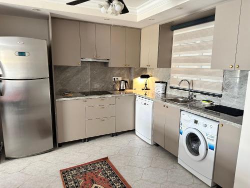 马尔马里斯Merkeze Yakın, Ev Rahatlığında的厨房配有冰箱、洗衣机和烘干机