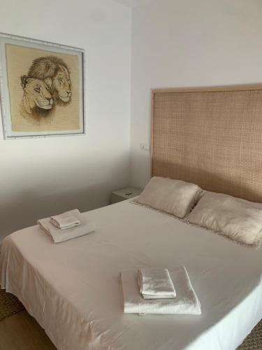 德尼亚Apartamento con terraza y acceso directo a piscina的卧室配有一张白色床,墙上挂着一幅画