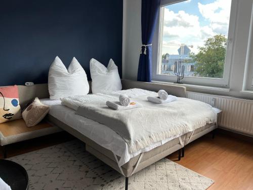 奥斯纳布吕克Große Wohnung im Zentrum von Osnabrück的卧室配有带白色枕头的床和窗户。
