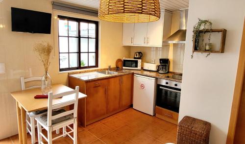 米尔芳提斯城Cantinho de Milfontes Jacuzzi的一间带桌子的厨房和一间带桌椅的厨房