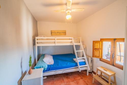 OnilCasa Cuquet de Llum Onil的一间卧室配有一张双层床和梯子