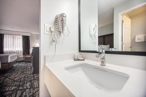 格兰德港Baymont by Wyndham Grand Haven的浴室设有大型白色水槽和镜子