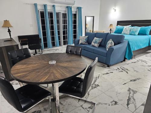 尼格瑞尔Roots Cafe Rooms的客厅配有蓝色的沙发和桌子