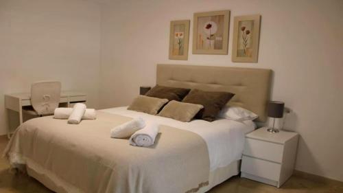 马贝拉Apartamento en Marbella junto a campos de golf的卧室配有带毛巾的大型白色床