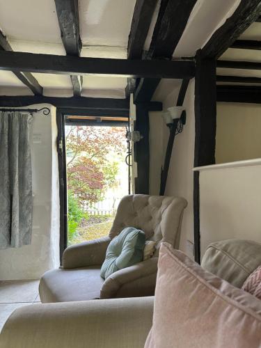 亨利昂泰晤士Gorgeous Cottage in Skirmett with Parking的客厅配有两把椅子和窗户