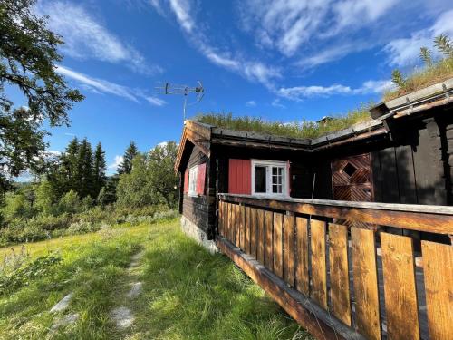 LundeElveseter - log cabin with an amazing view的田野上带围栏的木屋