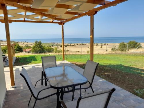 萨莫色雷斯Pezoulia Cottages的一个带桌椅的庭院和海滩