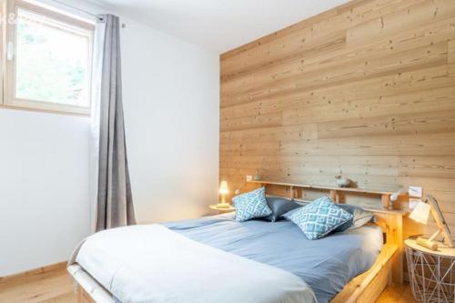 拉布雷斯Appartement Maïnou à La Bresse的一间卧室配有一张木墙床