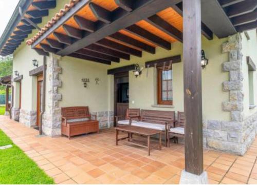 ArboleyaLa puerta de Fredo的房屋内带长凳和桌子的庭院