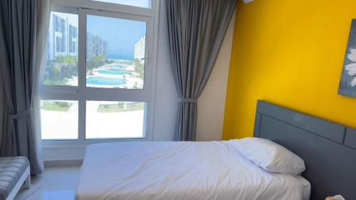 赫尔格达Direct Sea & Pool View FANADIR BAY的一间卧室设有一张床和一个大窗户