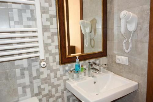 第比利斯爱丽恩精品酒店的一间带水槽的浴室和墙上的一部电话