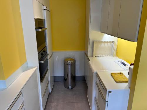 勒图凯-巴黎普拉日O2的一间设有黄色墙壁和垃圾桶的小厨房