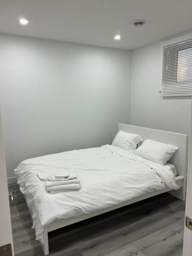 卡尔加里Newly built one bedroom 2 bed的白色的床、白色床单和白色枕头