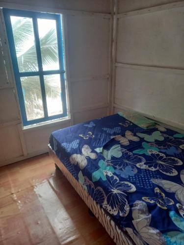 蒙塔尼塔La Cabaña的一张位于带窗户的蓝色毯子的房间里的床