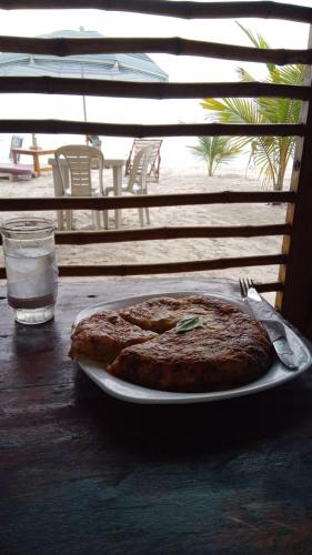 蒙塔尼塔La Cabaña的桌上的盘子上的比萨饼,加一杯水