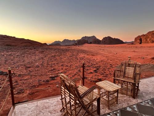 瓦迪拉姆瓦迪鲁姆天空之旅营地旅馆的沙漠中的两把椅子和一张桌子