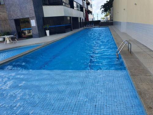 萨尔瓦多Maravilhosa cobertura duplex vista mar的大楼里的一个大型蓝色游泳池