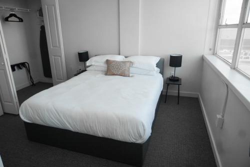 巴吞鲁日Entire High-Rise Apartment - 2BD的一间卧室配有带白色床单和枕头的床。