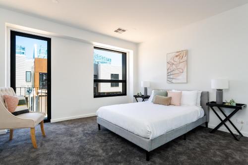 Port AdelaideUrban Rest Port Adelaide Apartments的白色卧室配有床和椅子