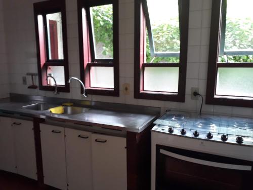 布希奥斯Ossos Beach House的厨房配有水槽、炉灶和窗户。