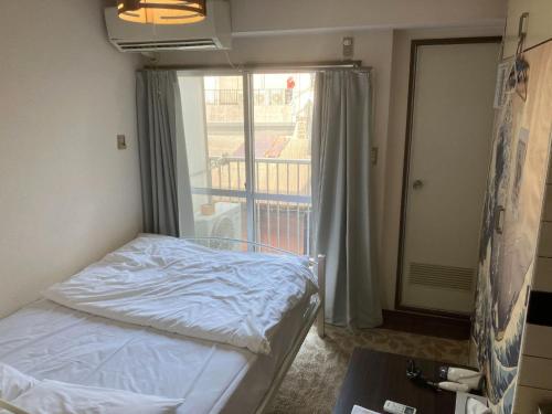 广岛Nishimoto Building - Vacation STAY 16010v的一间带床和阳台的小卧室