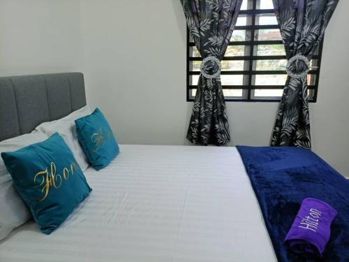 宋溪Adiniz@HotSpring Sg Klah的一张带蓝色和白色枕头的床和窗户
