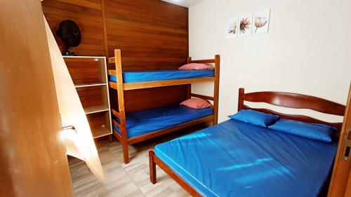 瓜拉图巴Casa Colonial em Guaratuba, próximo a praia的一间卧室配有两张双层床和一张蓝色的床。
