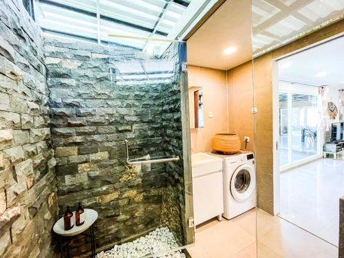 塞隆贝拉纳克Villa KOTAK Surfers Escape Reopening Rates apply now的一间带石墙、洗衣机和烘干机的浴室