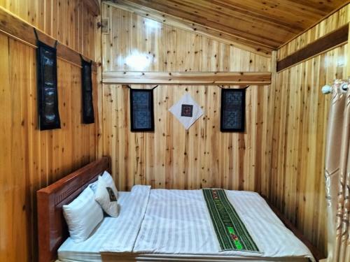 萨帕Sapa Shalom Homestay的卧室配有木墙内的一张床