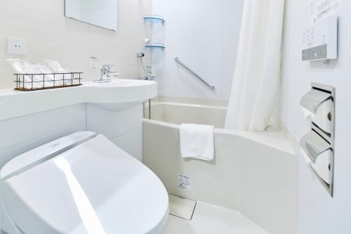 东京ICI HOTEL Tokyo Hatchobori的白色的浴室设有卫生间和水槽。