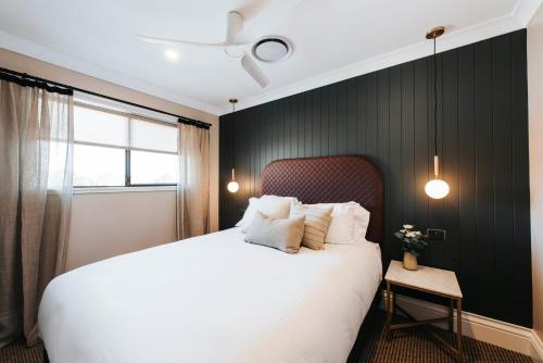 马奇McKenna Terraces的卧室配有白色的床和黑色墙壁