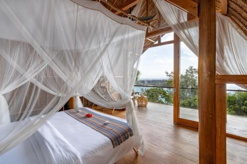 蓝梦岛Morin Resort的卧室配有带白色蚊帐的床