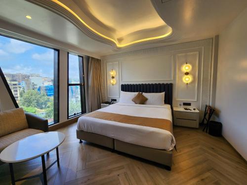 孟买Dragonfly Hotel- The Art Hotel的酒店客房设有一张大床和一张沙发。
