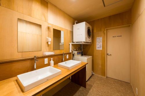 Mitsuhama三津ミーツ的一间带两个盥洗盆和微波炉的浴室