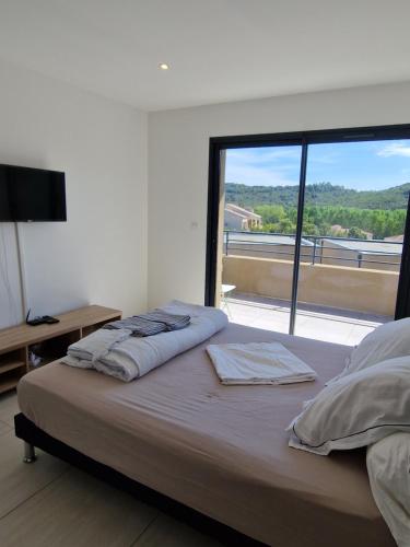 孔卡Villa Favone 4 chambres piscine privée的一间卧室设有一张大床和大窗户