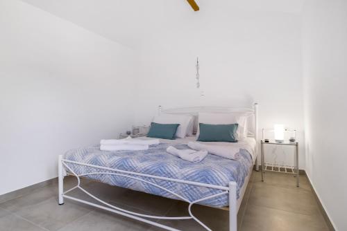 梅加尼西岛Scorpios View Meganisi的白色的床,配有蓝色和白色的床单和枕头